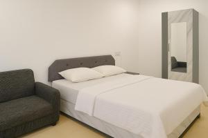 a bedroom with a bed with a chair and a mirror at The Nest in Trichūr