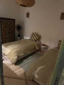 une chambre avec deux lits et une lampe dans l'établissement Riad E&J Marrakech Médina 5 ch climatisées, piscine chauffée, EXCLUSIF, à Marrakech 16 autres photos