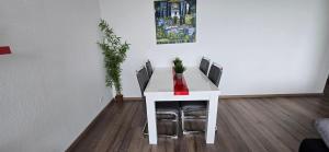 a white table with four chairs and a painting on the wall at Let's RelaxX 2-Rooms Free Parking in Mülheim an der Ruhr