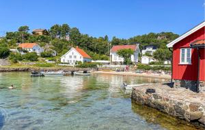 a body of water with a red house and boats at 2 Bedroom Lovely Home In Færvik in Færvik