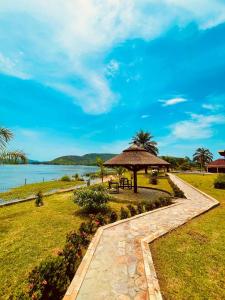 a walkway with an umbrella and a table and chairs at Platinum Blue Island Resort in Atimpoko