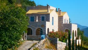 a house on a hill with a fence at Philothea Guest House Mani Greece in Mitziólena