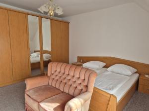 a bedroom with a bed and a chair and a mirror at Bio-Bauernhof Wilfling in Miesenbach