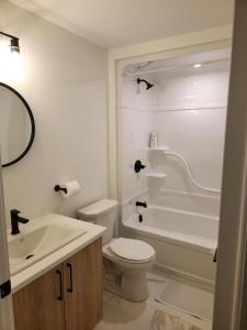 a bathroom with a toilet and a tub and a sink at Zeemah Lodge in Moncton +49 photos