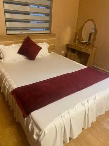 een groot wit bed met een rood kussen erop bij Thanh Lịch Homestay in Hanoi