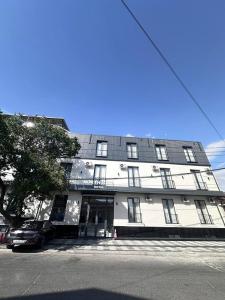 a white building with a car parked in front of it at North Star Hotel in Yakkasaray