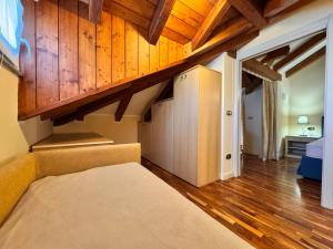 a bedroom with a bed and wooden walls and wooden floors at Appartamento Stresa in Dagnente +5 photos
