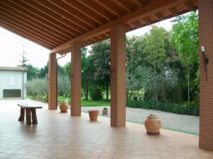 a pavilion with vases and a bench on a patio at Agriturismo Radaméz in Monzambano