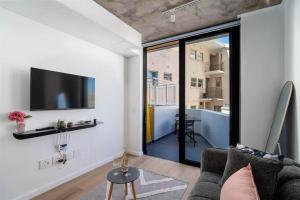 Una sala de estar con un sofá y un televisor en una pared. en Apartment in Seapoint, en Ciudad del Cabo