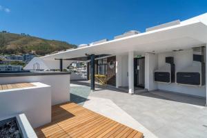 una casa blanca con patio y techo en Apartment in Seapoint, en Ciudad del Cabo 3 fotos más