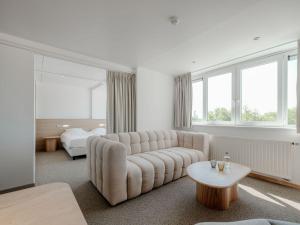 东代恩凯尔克瓦堪缇多美恩泰尔赫尔穆旅馆的客厅里有一张沙发和一张桌子。