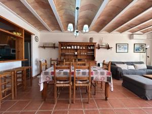a dining room with a table and a couch at ES BERRY 3 by SOM Menorca in Fornells