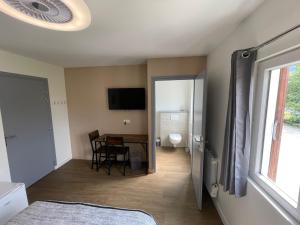 a bedroom with a table and a room with a toilet at Chambre le Faucon in Cernon +10 photos