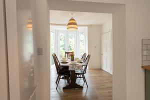 ランゴレンにあるStylish and spacious four-bedroom cottage by the river Eco-friendly hot tub, cozy open fireplace Beautiful viewのテーブルと椅子のあるダイニングルーム