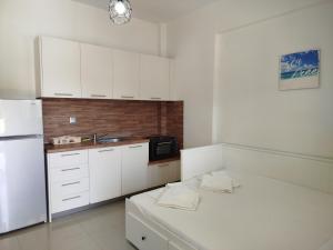 a kitchen with white cabinets and a white refrigerator at Ioannas in Nikiti