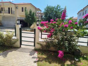 a garden with pink flowers and a gate at Ioannas in Nikiti