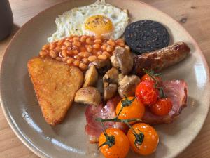 a plate of breakfast food with eggs beans and toast at Rooms at the Inn in Trotton +5 photos