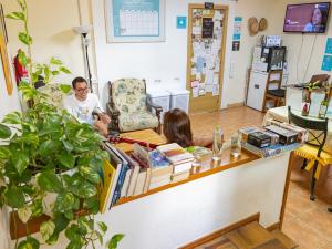 a man and a woman sitting at a counter in a room at Arena Nest Hostel in Puerto de Santiago