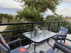 a table and chairs on a balcony with the ocean at Seaside Apartment Kato Diminio in Káto Dhiminión