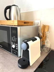 a black and white microwave sitting on a counter at Gîte Le 25 in Ingersheim