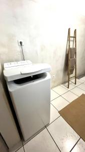 a bathroom with a white sink on a tiled floor at Gîte Le 25 in Ingersheim