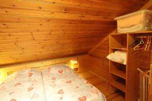 a bedroom with a bed in a wooden room at Chalet des Brimbelles, séjour au cœur de la nature au cœur de la vallée des lacs in Xonrupt-Longemer