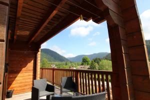 a view from the deck of a cabin with chairs at Chalet des Brimbelles, séjour au cœur de la nature au cœur de la vallée des lacs in Xonrupt-Longemer