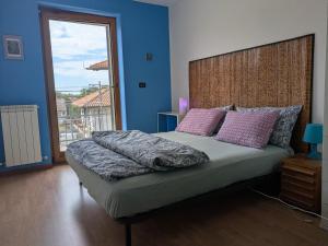 a bedroom with a large bed with a large window at Serenissima in Monfalcone