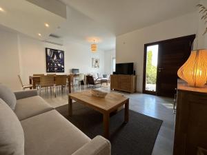a living room with a couch and a table at MARINA 24 by SOM Menorca in Fornells