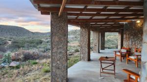 a porch of a house with a view of the mountains at Shama Lodge - "Dassiekrans Guesthouse" in Steytlerville