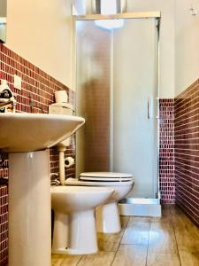 Un baño con inodoro, lavabo y ducha. en La Madonnina, en Noto