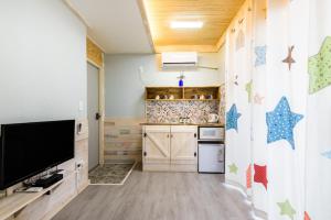 a kitchen with a flat screen tv on a wall at White star in Jeju +10 photos