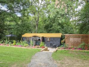 a small shed with a yellow roof in a yard at Charltons Hollow Cabin in Haywards Heath