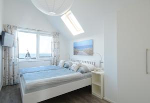 a white bedroom with a bed and a window at Ferienwohnung Wilbur Olpenitz in Olpenitz