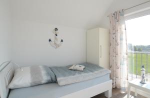a white bedroom with a bed and a window at Ferienwohnung Wilbur Olpenitz in Olpenitz