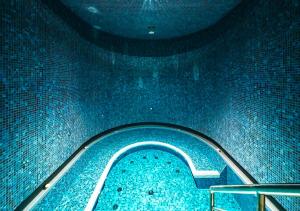 a swimming pool with a blue floor and a stairs at Kimpton BEM Budapest by IHG in Budapest