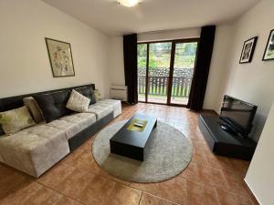 a living room with a couch and a table at Private apartment in Prespa in Bansko