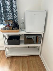 a white shelf with a microwave on top of it at The Bungalow by SJP in Northamtonshire