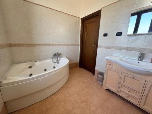 a bathroom with a tub and a sink at B&B Anna in Marigliano