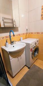 a bathroom with a sink and a washing machine at Апартаменти Greenhouse in Kropyvnytskyi +1 photo