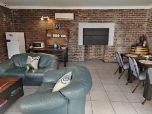 a living room with a couch and a brick wall at Wildebeespan Guest Farm in Delareyville