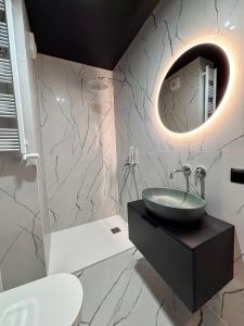 a bathroom with a sink and a mirror at Apartamenty WHITE GLOVE Parkya Central Park in Olsztyn