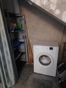 a white washing machine in a room with a cat at Ureki Village Guest House in Ureki