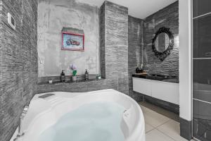 a bathroom with a white tub and a sink at Luxury House Jacuzzi - Milano in Milan