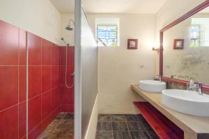 a bathroom with a sink and a mirror at Villa du Bonheur, maison de luxe en bord de mer by IHR in Roches Noires +49 photos