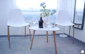 a bottle of wine on a table with two chairs at La Pavoncella in Oristano
