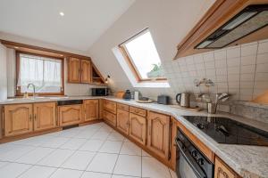 a kitchen with wooden cabinets and a sink and a window at Le Nid Alsacien - Typique et Charmant in Hochfelden
