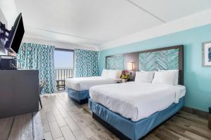 派恩诺尔肖尔斯Crystal Coast Oceanfront Hotel的一间有两张床和一台平板电视的酒店房间