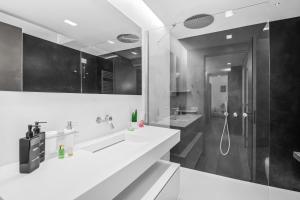 a white bathroom with a shower and a sink at Luxury Brera apartment - Corso Como 9 in Milan