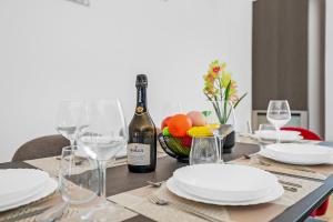 a dining table with a bottle of wine and glasses at Luxury Brera apartment - Corso Como 9 in Milan
